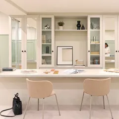 The central workstation at our Furbishy HQ, designed for team collaboration. The long desk provides ample space, while the glass-fronted cabinetry behind it offers stylish storage and display for material samples and decor.