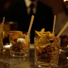 My Mexican Rice is served in individual glasses for a convenient and stylish appetizer. It's a flavorful mix of seasoned rice, beans, and corn, topped with a dollop of sour cream.