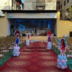 This photo shows the entrance aisle for a large naming ceremony held in a community hall. I lined the red carpet with character cutouts on balloon pillars to build excitement as guests walk towards the main stage.