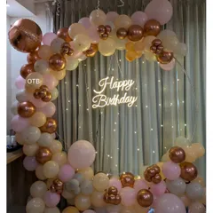 A close-up of the pastel birthday ring, highlighting the "Happy Birthday" neon sign and the beautiful mix of peach, cream, and rose gold chrome balloons.