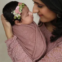 A tender close-up from a newborn photoshoot, capturing the delicate features of the baby and the mother's loving gaze. These quiet moments are so precious.