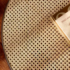 A detailed close-up of the intricate cane weaving on the coffee table. This traditional craft requires great skill and attention to detail.