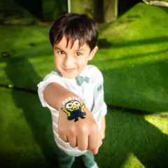 The birthday boy proudly shows off his new Minion temporary tattoo. Party activities like face painting and tattoos make for great photo opportunities.