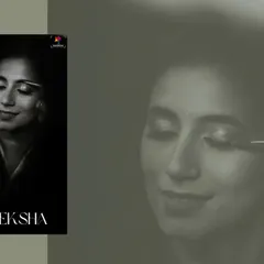 A dramatic black and white portrait of the bride during her makeup session. The focus on her closed eyes and the artist's brush creates a moment of quiet anticipation.