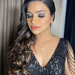 The perfect cocktail party glam. This look is all about a dramatic, classic smokey eye balanced with a soft nude lip. The side-swept curls add a touch of Hollywood elegance, ideal for an evening celebration.