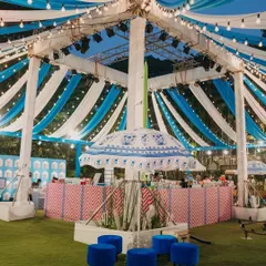 A central view of the Haldi setup, featuring a custom-printed umbrella and lounge area. The blue and white theme, inspired by Jaipur's Bar Palladio, offered a chic and modern alternative to typical Haldi colors.