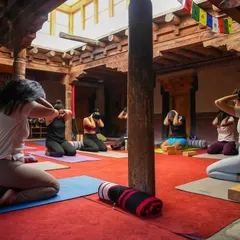 A moment of collective breathwork during our Ladakh retreat at Nimmu House. The traditional wooden architecture and prayer flags create a sacred space for us to practice together, moving as one.