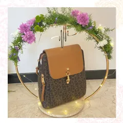 Presenting luxury accessories with flair. This Calvin Klein backpack is displayed on a custom golden ring stand adorned with fresh flowers and fairy lights, making the gift itself an experience.