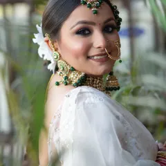 An elegant and fresh look for a bride in a white saree. I used a green smokey eye to match her jewelry and kept the rest of the makeup luminous and natural.
