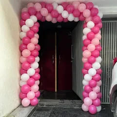 The entrance to the party, decorated with a pink and white balloon arch to welcome guests.