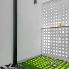 This small balcony space is transformed by the light filtering through the perforated screen. The design provides a private outdoor nook that feels connected to the outside world without being fully exposed.