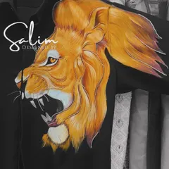 A close-up of a hand-painted roaring lion on the shoulder of a black shirt. The detail and color work showcase the level of artistry I bring to my custom pieces.