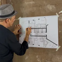 On-site at 'Project 58W,' a 5,000 sq ft residence in South Bombay. Here, the principal architect reviews the floor plans against the raw structure, ensuring every detail aligns with the vision of framing the panoramic city views.
