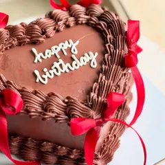 Too cute to eat, too pretty not to post. A rich chocolate heart cake with detailed piping and bold red satin ribbons, perfect for a classic and romantic birthday celebration.
