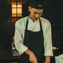 A smiling chef chops ingredients, reflecting the positive energy of our team.
