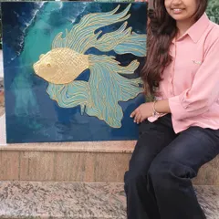 A student proudly displays the textured fish wall art she created in my professional workshop. The piece uses cone art and gold foil to create a stunning 3D effect on a resin background.