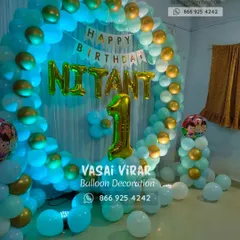 A simple and elegant ring backdrop for a first birthday. The combination of light blue and gold balloons creates a classic look, personalized with the birthday boy's name and a large number '1' foil balloon.