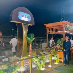 A guest poses by our stylish Italian counter, which features a striking gold pillar and elegant floral decor.