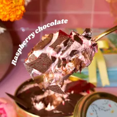 A close-up of our Raspberry Chocolate Dream Cake, showing the perfect bite. The combination of tart raspberry, rich chocolate, and light cream is absolutely irresistible.