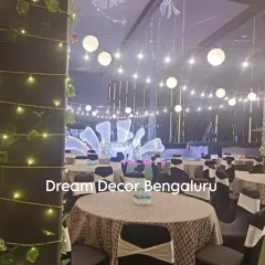 A view of the guest seating area for the anniversary party. The string lights, paper lanterns, and elegant table settings all contribute to a cohesive and beautiful event design.
