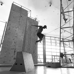 This dynamic shot shows a practitioner clearing an obstacle with a powerful jump. Our training helps you develop the explosive strength needed for these kinds of movements.