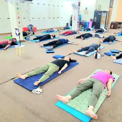 Participants in a guided relaxation session during one of our wellness workshops. Here, we learn to truly let go in Savasana, preparing the body and mind for deep, restorative rest and helping to manage daily stress.