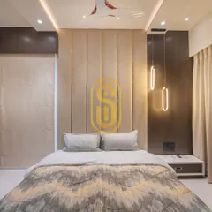 An elegant bedroom featuring a floor-to-ceiling upholstered headboard with vertical brass inlays. The modern pendant lights on either side of the bed serve as both functional reading lights and stylish decor.