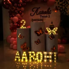 A close-up of a simple birthday setup, highlighting the illuminated marquee letters and butterfly details on the pedestals. This shows how small touches can make a big impact.