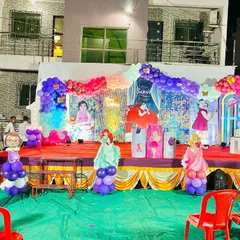 A full view of an outdoor princess-themed birthday party stage. I designed this setup with multiple character cutouts, a shimmering backdrop, and elaborate balloon garlands in pink, purple, and blue to create a magical kingdom for the birthday girl.