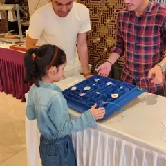 A young girl carefully navigates the wire maze, demonstrating intense concentration. These games are not just fun, they also help develop patience and precision.