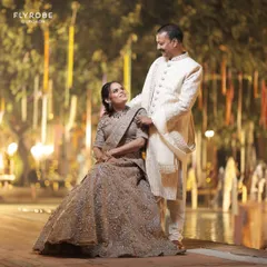 A beautiful, candid moment between the couple, showcasing their stunning coordinated ethnic wear against a backdrop of fairy lights.