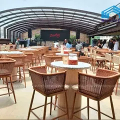 This retractable roof transforms a restaurant's outdoor seating area, ensuring business is never interrupted by weather. The system is shown here fully extended, covering the entire space.