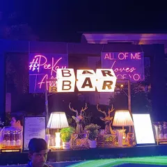 A full view of our glamorous bar setup for a sangeet night, complete with custom neon signs like '#PeeKeTalli' and romantic quotes. This shows how we can create a high-energy focal point for your celebration.