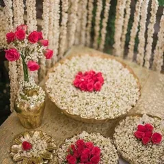 Traditional floral decorations using jasmine and rose petals. This type of intricate floral art, often placed in water-filled urlis, adds a beautiful and fragrant element to any celebration.