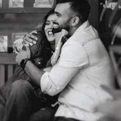 A spontaneous, heartfelt hug in a cafe. The motion blur and black and white finish add to the feeling that this is a real, captured moment, not a staged pose.