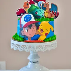 Gotta catch 'em all. This Pokémon-themed cake is perfect for any fan, featuring Ash, Pikachu, and other favorite characters as edible toppers on a vibrant blue and green cake.
