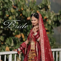 A stunning full-length portrait of the bride in her red wedding lehenga, posing against the backdrop of the Rishikesh hills.