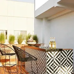 A rooftop bar is the ultimate feature for entertaining. I designed this bar with a bold, geometric-tiled front and a solid wood top, set on a wooden deck to create a stylish, modern hub for social gatherings.