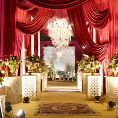 An entrance that screams 'Ruby Romance'. We used luxurious red drapes and a carpeted walkway flanked by floral arrangements to create a grand and passionate welcome for the wedding guests.