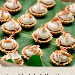 A tray of my Anjeer Halwa Tarts with Almond Cream. The traditional fig-based sweet is given a modern twist, served in a crisp tart shell and topped with fluffy cream and toasted almonds.