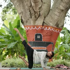 Me in a dynamic side plank variation, practicing under a sacred tree.