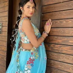 A dreamy look for a Haldi ceremony. The bride's light blue floral lehenga is paired with a beautiful bubble braid, creating a look that feels like it's straight out of a fairytale.