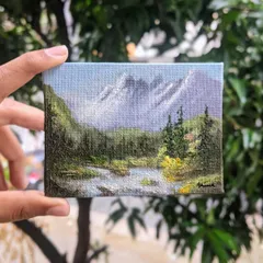 Holding this 3x4 inch canvas lets you see the details up close. I used different shades of green to paint the forest and added texture to the water to make this miniature landscape feel alive.