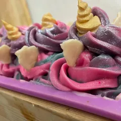 A close-up of the Unicorn soap loaf, showing the piped frosting and golden horns. I only use skin and earth-friendly glitters for that magical sparkle.