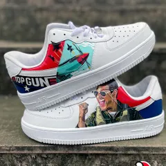 Our custom 'Top Gun' Nike AF1s, featuring a portrait of a celebrating Tom Cruise as Maverick on one shoe and a fighter jet scene on the other. The design is tied together with the iconic red, white, and blue Top Gun logo.