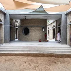 The central courtyard at Sai Kirupa Special School in Tiruppur, featuring a sensory room and shaded gathering spaces under a tensile fabric roof. The architecture is designed to be a therapeutic and engaging environment for children with special needs.
