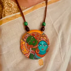 The timeless elegance of a Kerala mural painting on a wooden pendant. Paired with a traditional Kasavu saree, this piece captures the subtle grace of South Indian art, making it a statement of cultural pride.