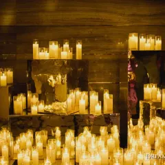 A sea of candles set on mirrored pedestals creates an infinitely reflective, magical glow. I use lighting as a primary tool to sculpt spaces and create a warm, intimate, and dramatic ambiance.