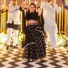 A bride leads her groomsmen in a fun group dance. We choreograph inclusive performances that bring both sides of the family together on the dance floor for a memorable sangeet night.