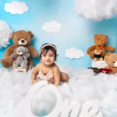 A dreamy first birthday setup with fluffy clouds and teddy bears, creating a magical sky scene.